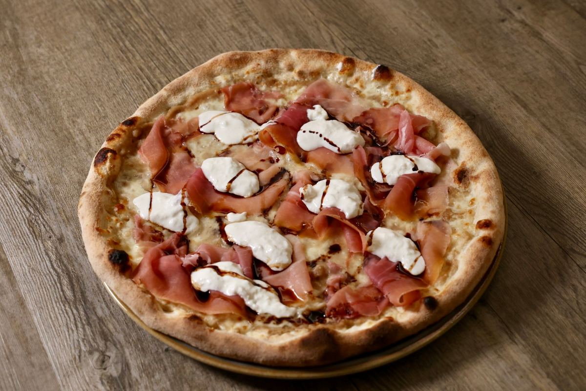 Pizza con crema di castagne, crudo di Parma e burrata della Pizzeria La Tavernetta