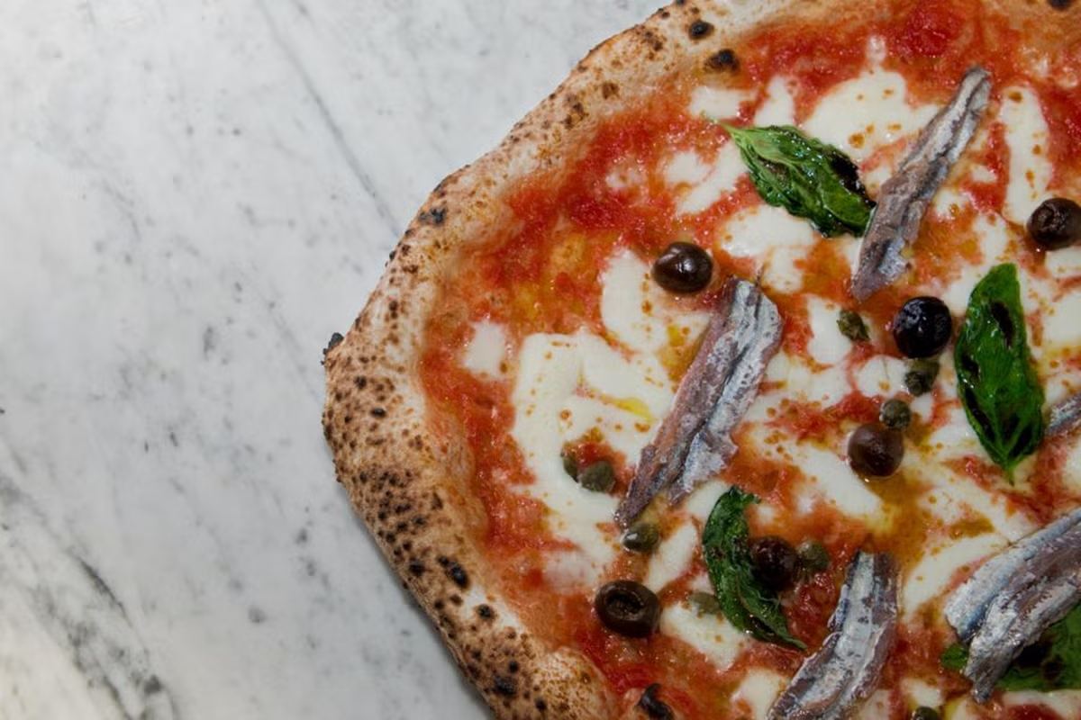 Pizza napoletana appena sfornata dal forno a legna di Frijenno Magnanno