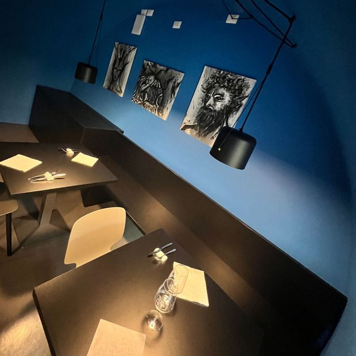 Sala blu di RiPizziCo con tavoli apparecchiati e arredi moderni