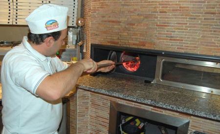 Giuseppe Palermo prepara la pizza al forno a legna