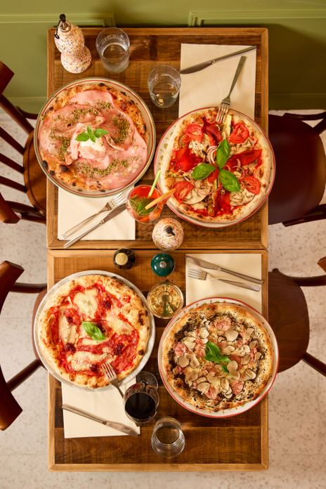 Mesa con pizzas artesanales y vinos en Osteria degli Amici