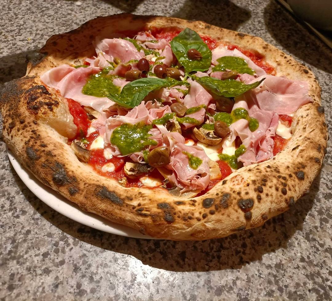 Pizza napoletana servita al tavolo della Pizzeria d'Alexis