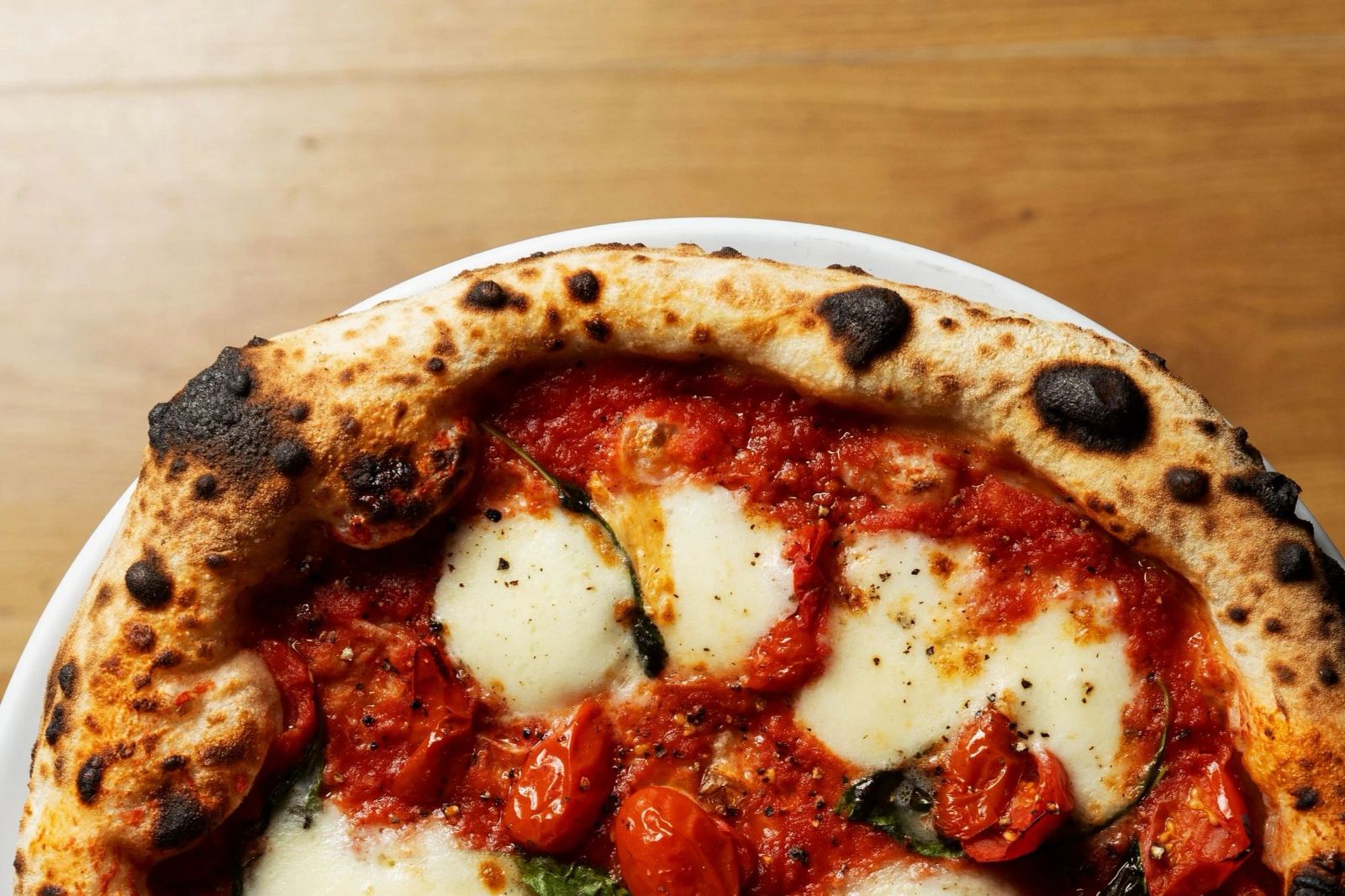 Pizza napoletana con mozzarella, pomodorini e basilico di The Pizza Vagabond