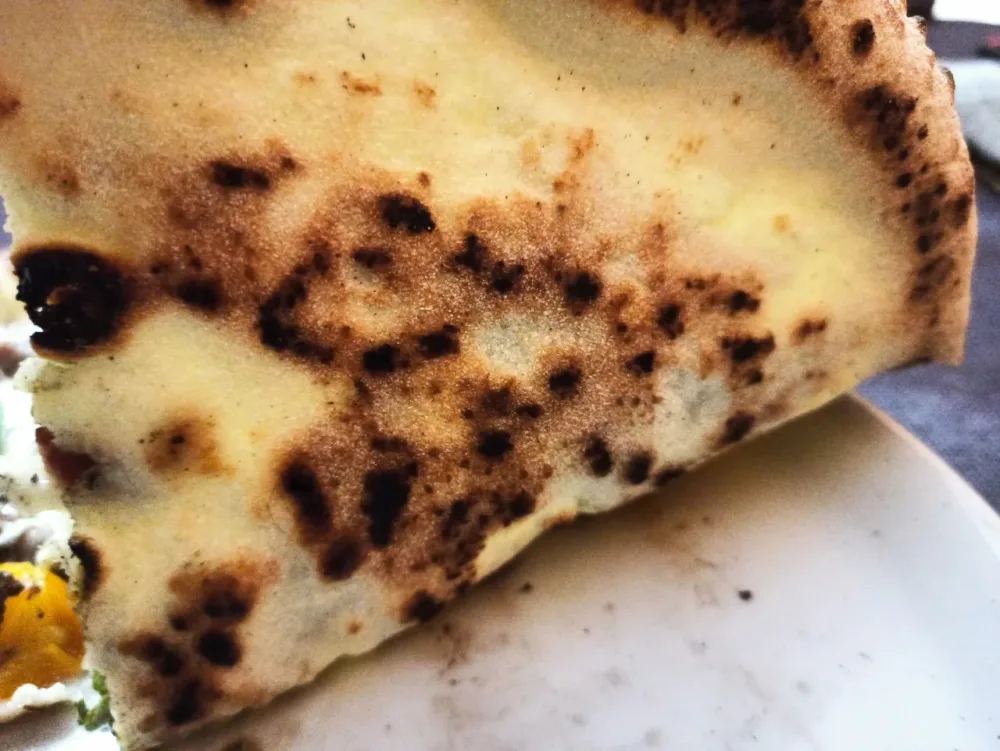 La cottura della pizza nel forno a legna di Bella 'Mbriana