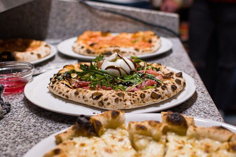 Selezione di pizze servite al tavolo al ristorante L'AROMA