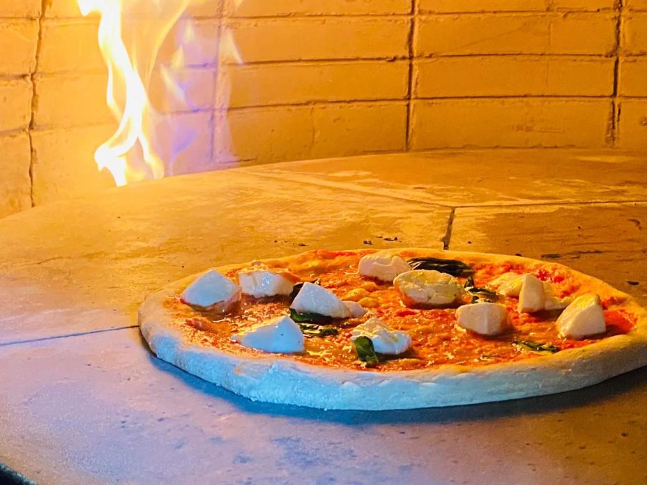 Cottura della pizza nel forno a legna di PIZZERIA SOEL