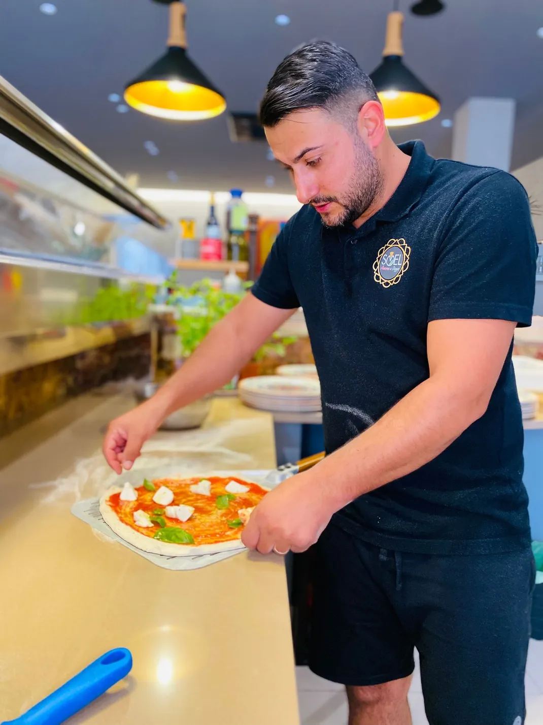 Il pizzaiolo Florian al lavoro nella cucina di PIZZERIA SOEL